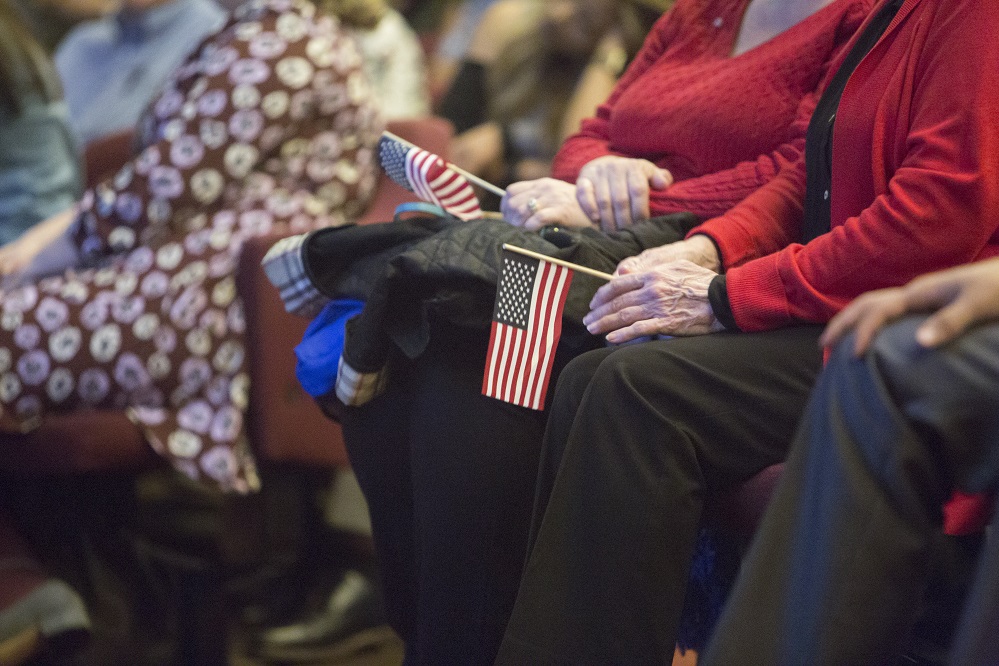 A pair of hands holding an American flag