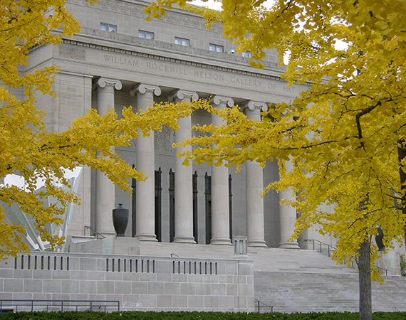 South portico of the Nelson-Atkins building viewed through trees in the fall.