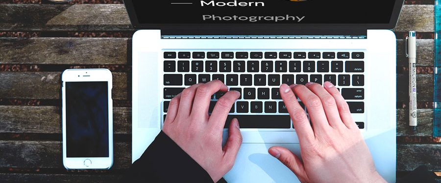 Close-up of two hands typing on laptop