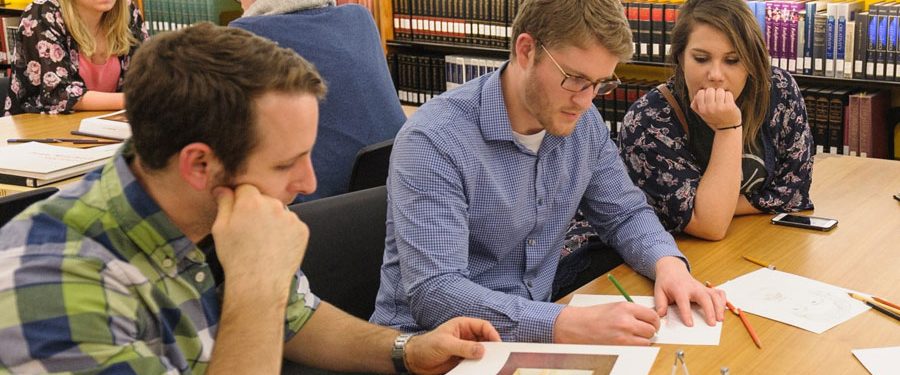 Two groups of people working at library tables