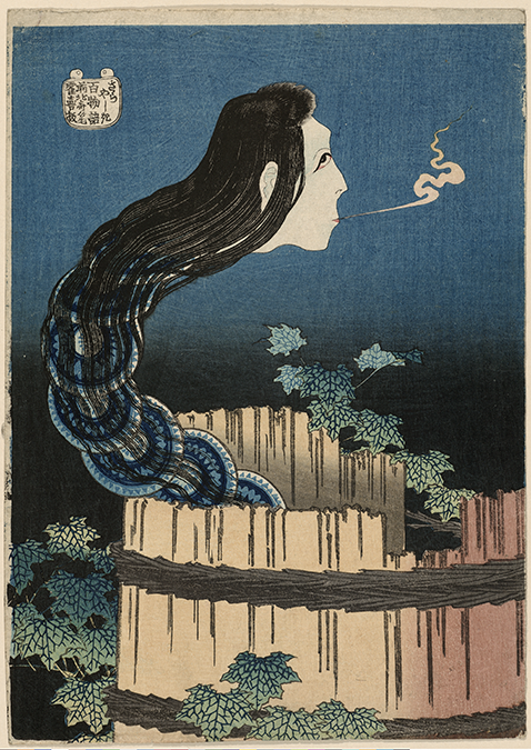 A pale head with long black hair blowing a puff of smoke trails out of a barrel into the air. 