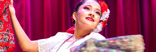 Beautiful dancer in traditional Mexican dress performing during the Día de Muertos festival