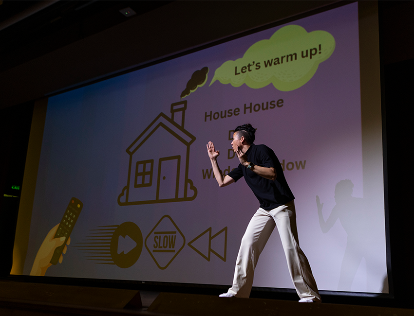 Image of presenter on stage signing