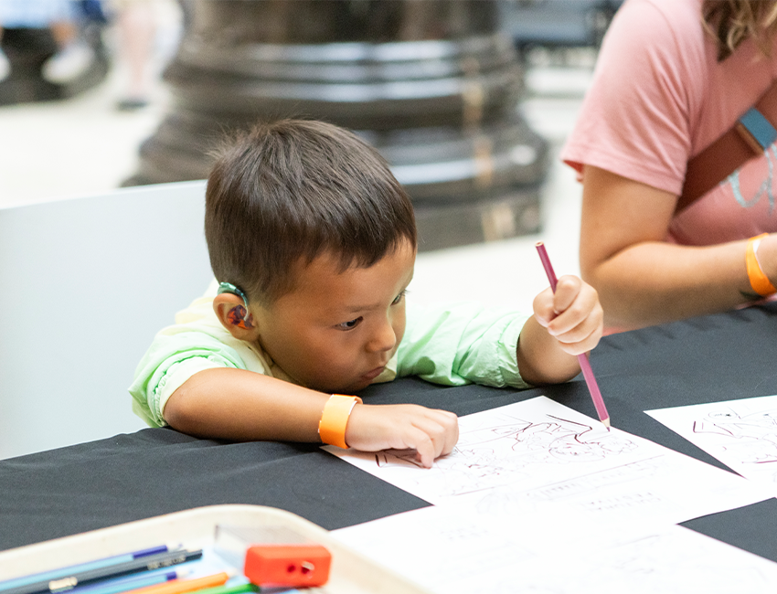 Image of small child drawing with colored pencil