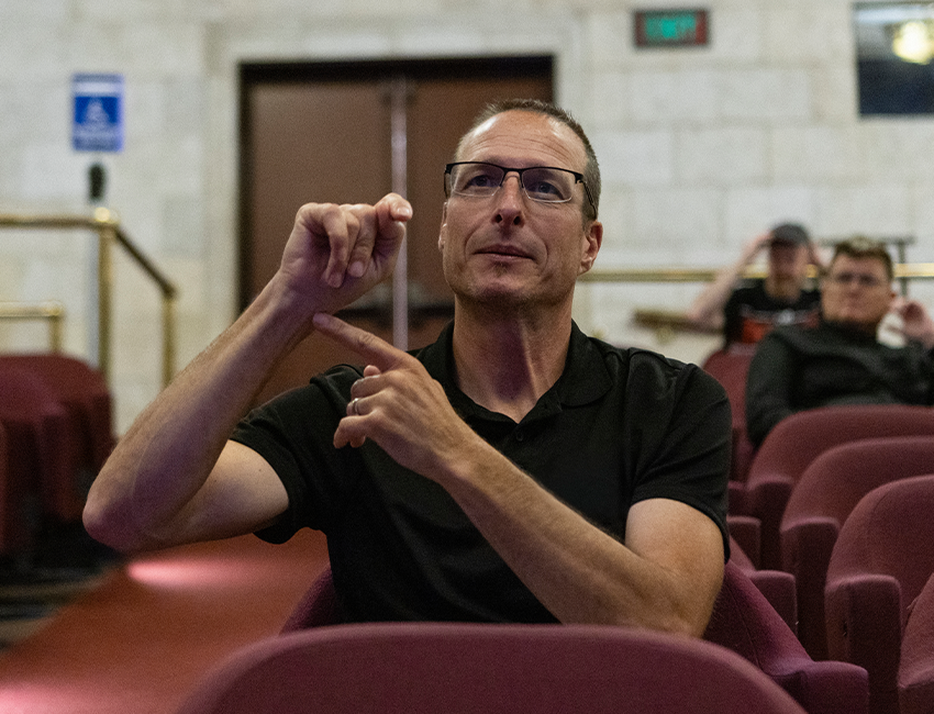 Image of person gesturing with hand in theater