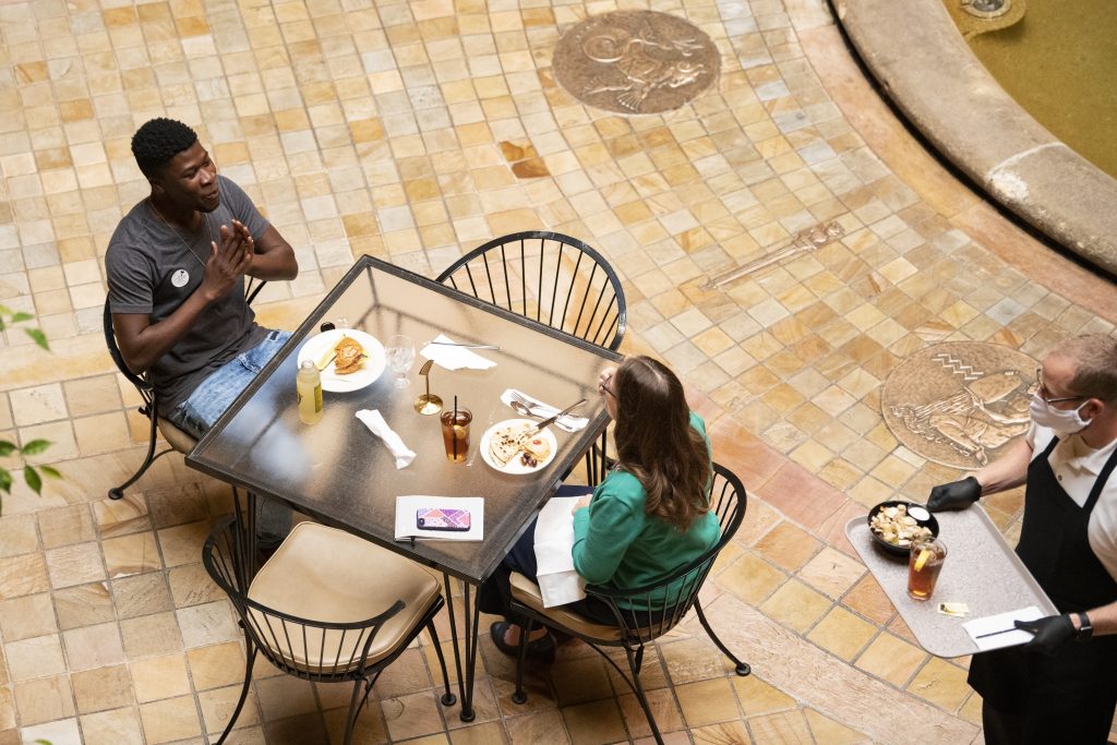 Two people eating lunch at a glass table in Rozzelle Court.