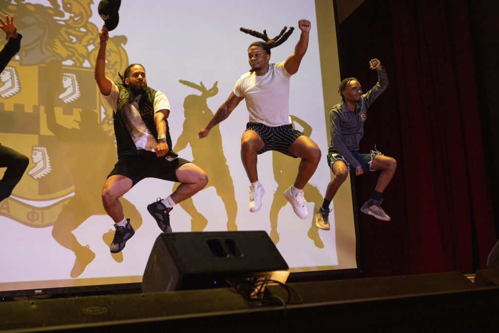 Dancers photographed in mid-air on stage in Atkins Auditoriums at the Nelson-Atkins Juneteenth Celebration.