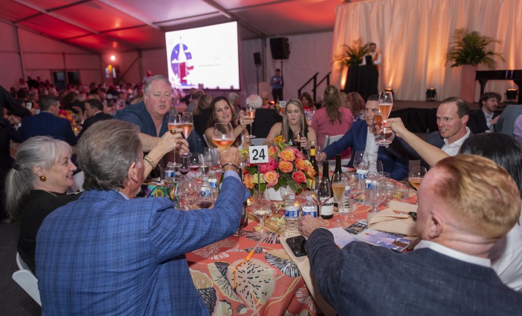 People toast their wine glasses at The Nelson-Atkins Museum of Art's ShuttleCork auction.