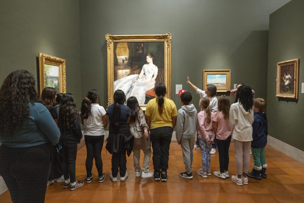 A group of young people gaze a painting in a gallery at The Nelson-Atkins Museum of Art.