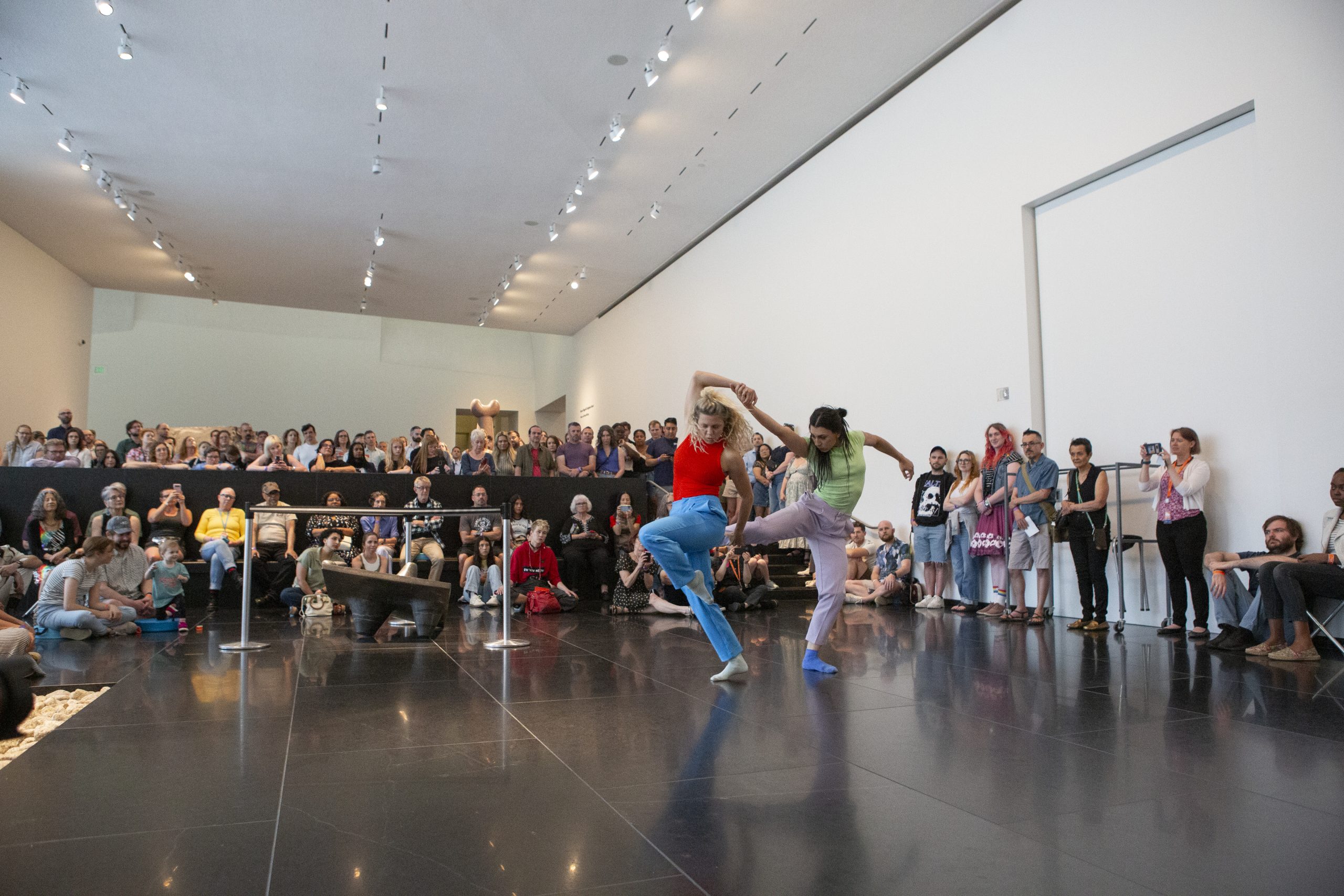 Two dancers perform in front of a crowd in Noguchi Court at the Nelson-Atkins.