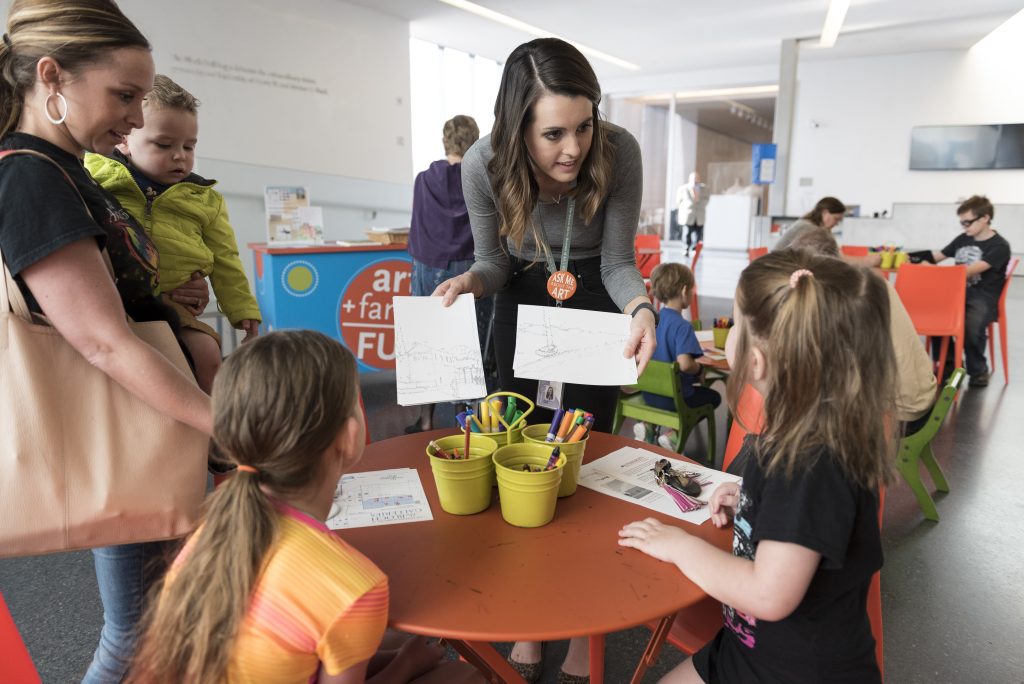 A Nelson-Atkins instructor offers activities to two children at a Free Weekend Fun event.