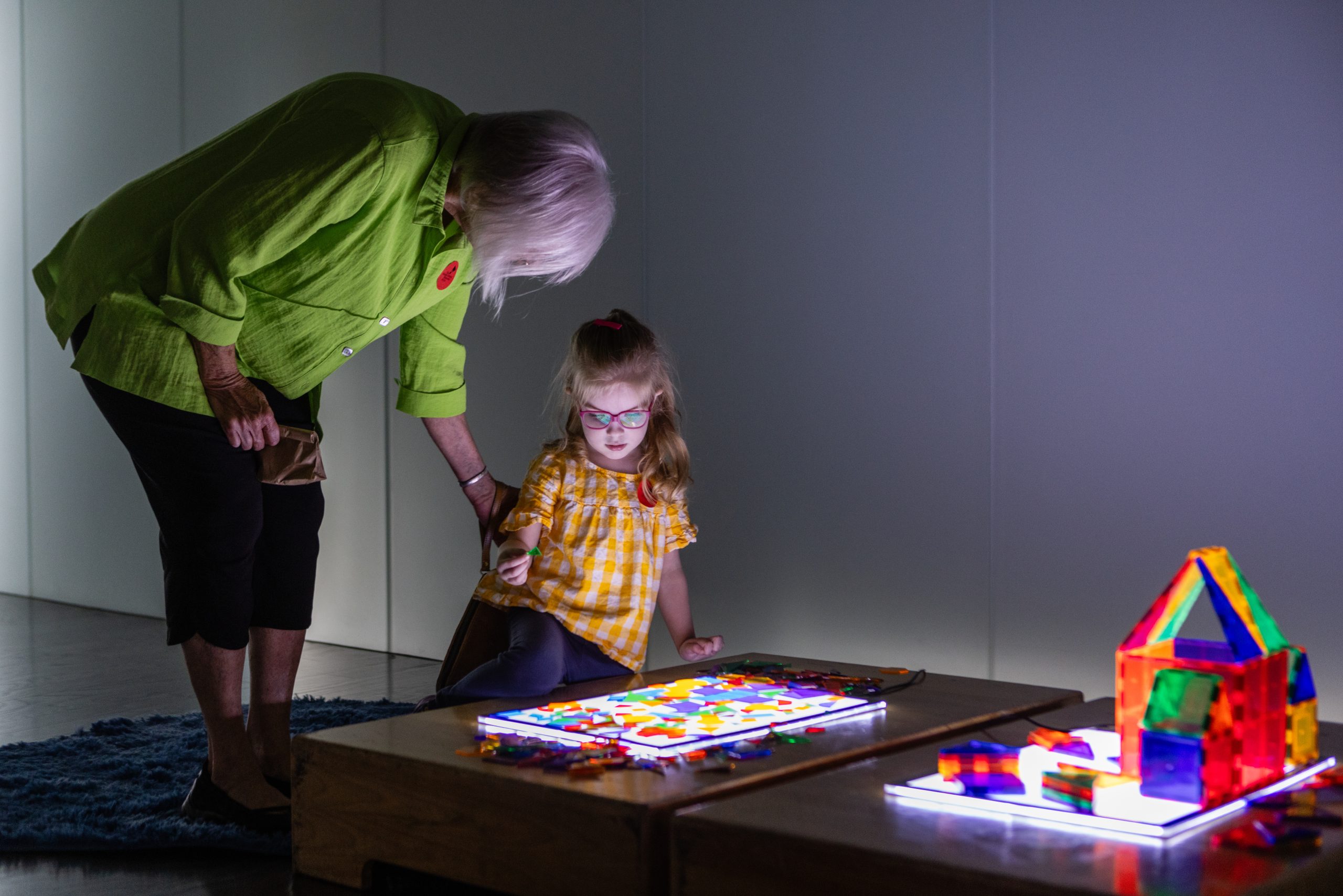 A Nelson-Atkins staff member assists a young girl playing with toys during a Low Sensory Morning activity.