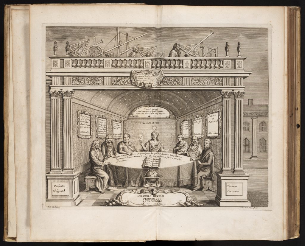 Illustration from book pages of 16th century scholars seated around a table.