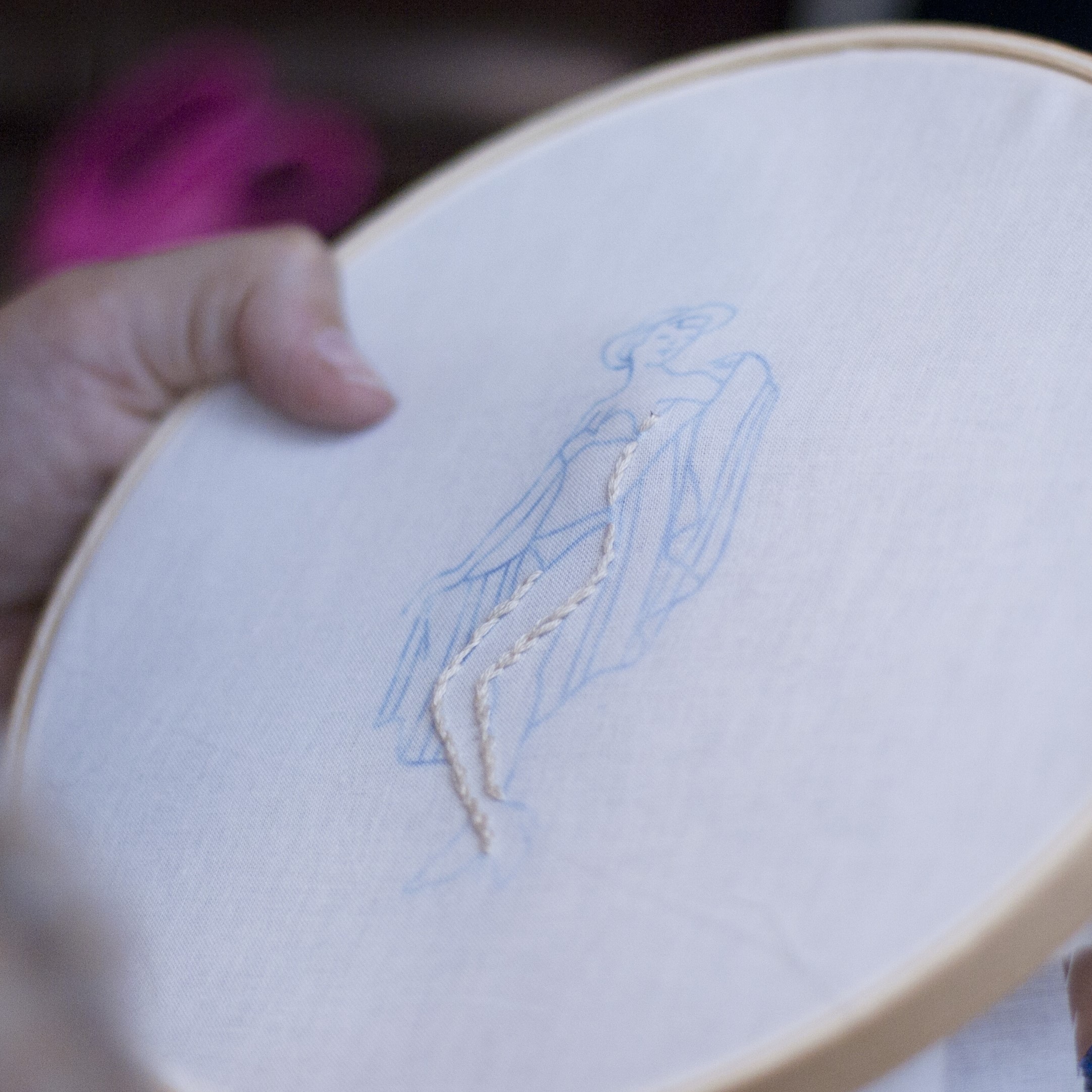 A person adjusting paintbrushes in their apron.