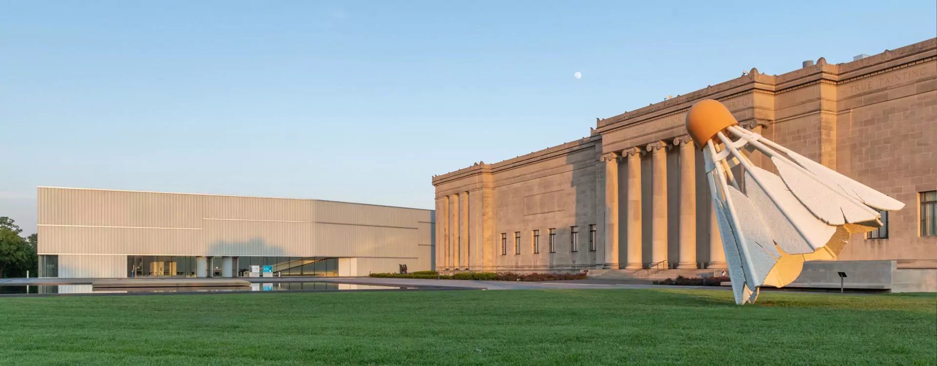 North entrances of the Nelson-Atkins showing both the column-clad original entrance and the modern Bloch building entrance. The Lawn is green with a large Oldenberg sculpture, Shuttlecock in view.