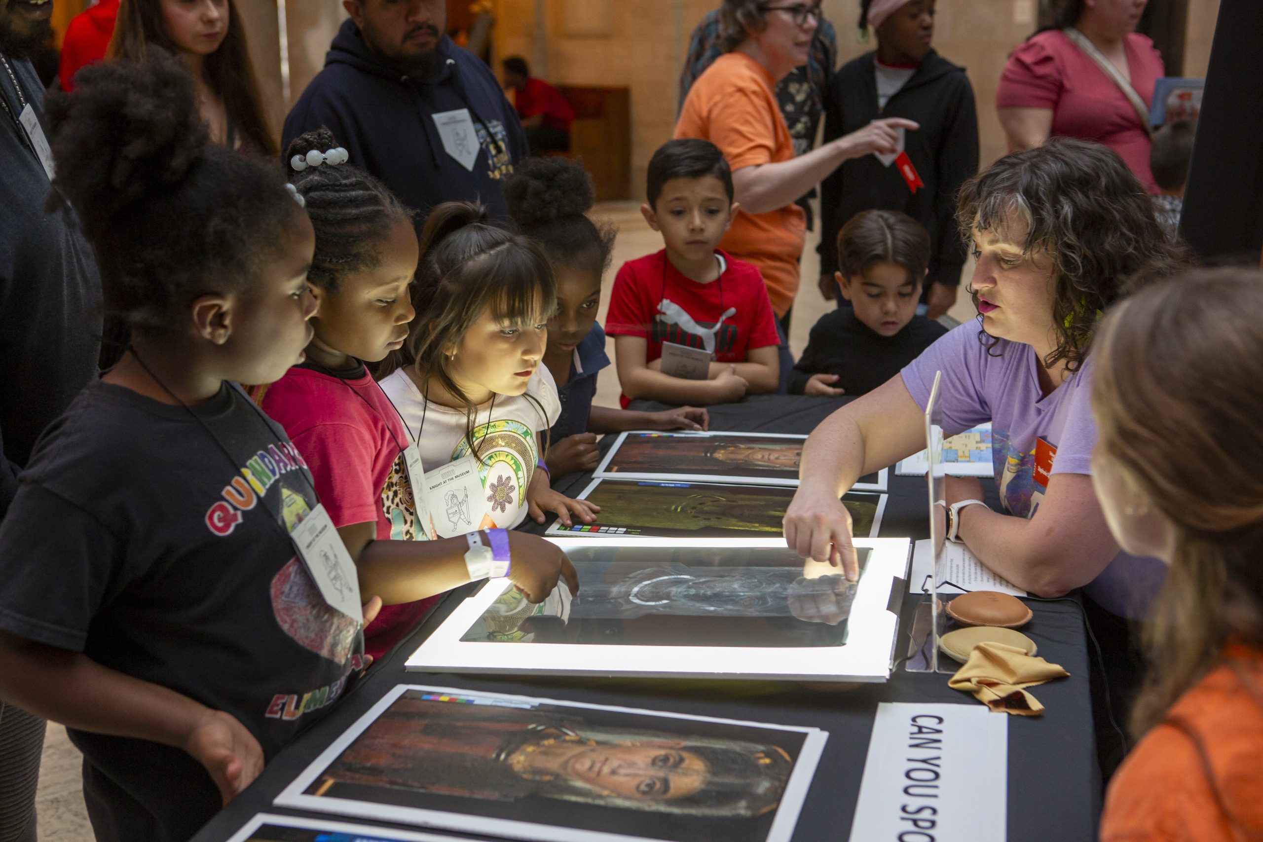 Group of children learning in front of xrayed artworks