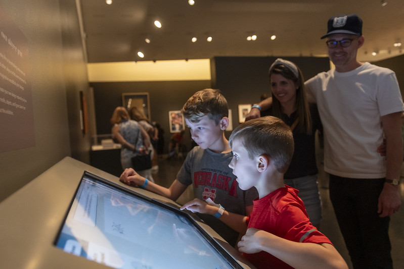 Family looks at a digital art interactive screen.