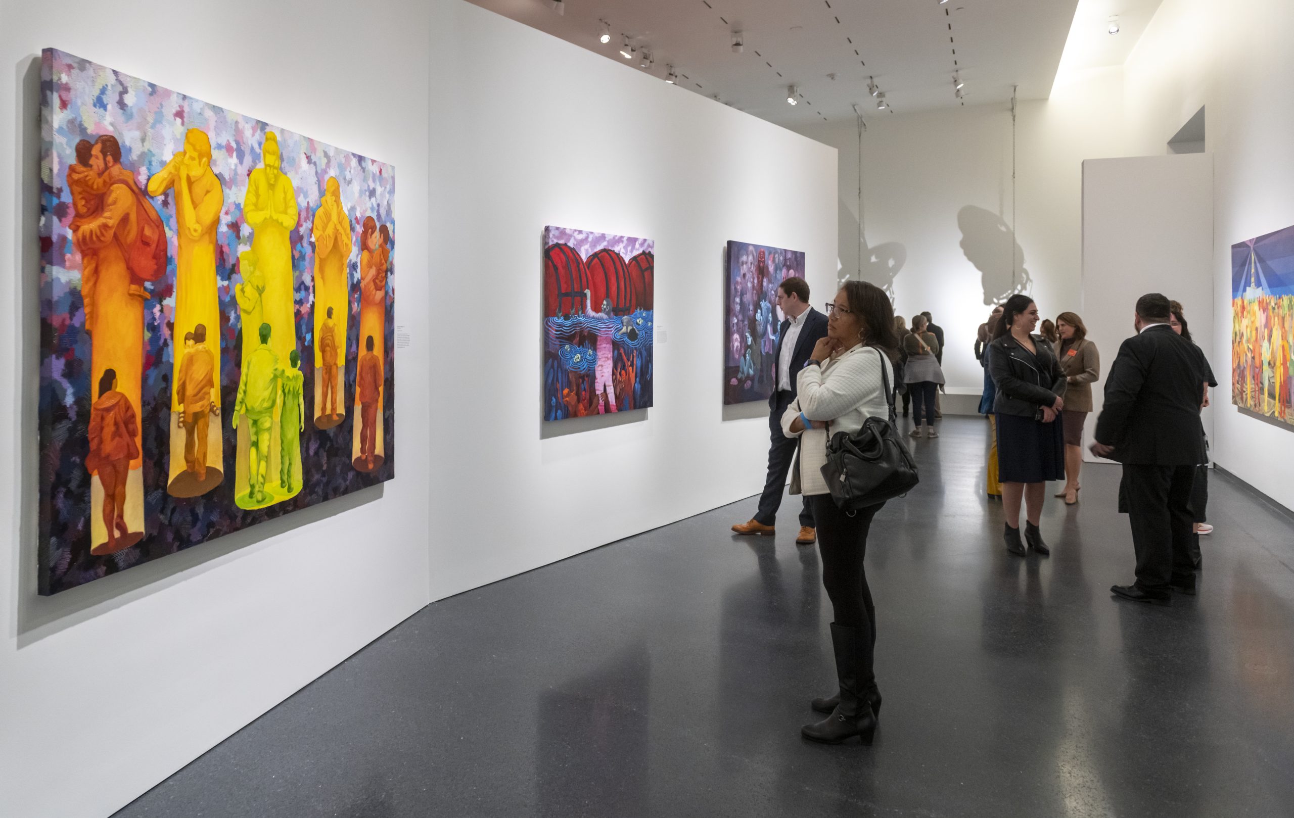 Guests look at paintings in the exhibition 2024 Charlotte Street Visual Artist Awards at the Nelson-Atkins.