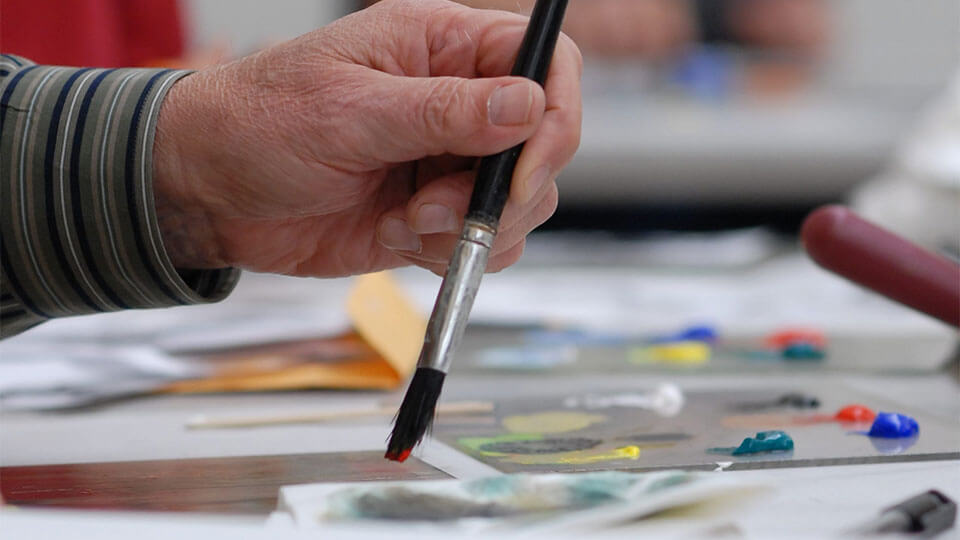 Art supplies ranging from scissors to colored pencils in varius cans.