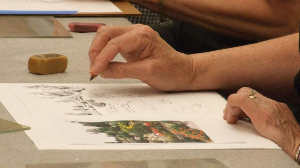 Art supplies ranging from scissors to colored pencils in varius cans.