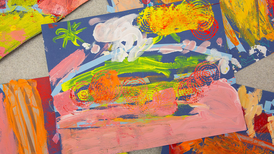 Colored pencils layed out over a drawing on paper.