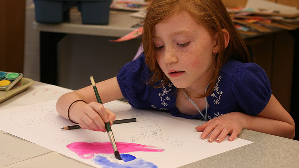 Art supplies ranging from scissors to colored pencils in varius cans.