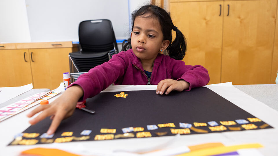 A person adjusting paintbrushes in their apron.