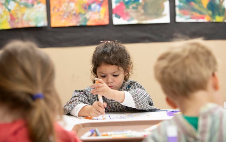 Art supplies ranging from scissors to colored pencils in varius cans.