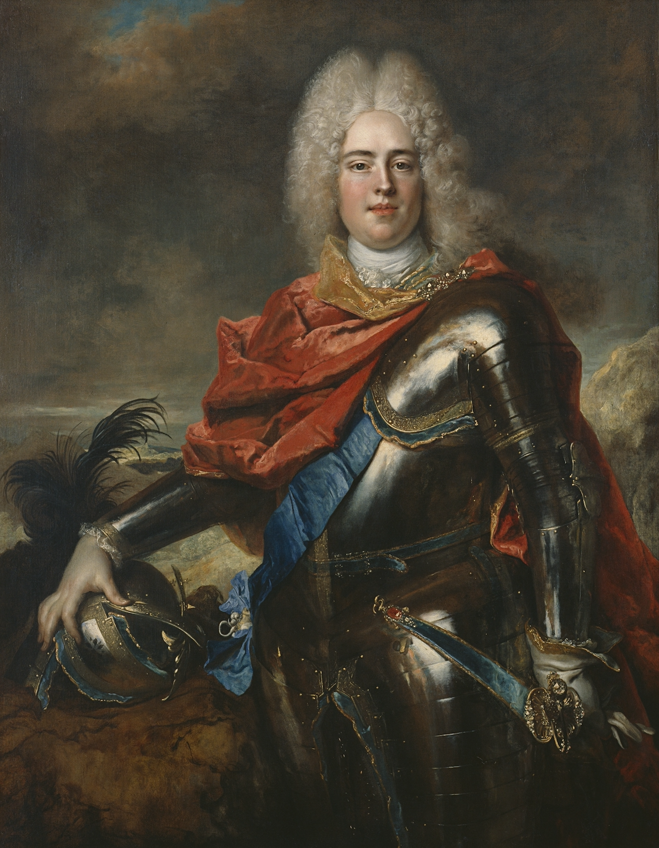 A portrait of a pale-skin-toned man in silver armor with gold accents around each plate’s edge. The man has a bright red cape wrapped around his neck and going over his back, while a blue stash crosses over their heart.  He wears a while glove on his left hand as it rests on a hold sword hilt. His right hand holds onto a metal helmet with a large black feather plume. The background constants of gray and brown clouds covering a blue sky. On the ground, there is a variety of rocky terrain.