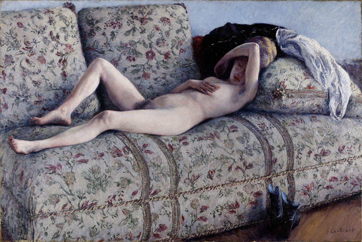 A painting depicting a nude woman laying on a white sofa with floral designs. Her right-hand lays on her chest while her left arm covers the top of her face. Her head rests against a pillow and what seems to be clothing. There are black boots on the wooden floor next to the sofa.