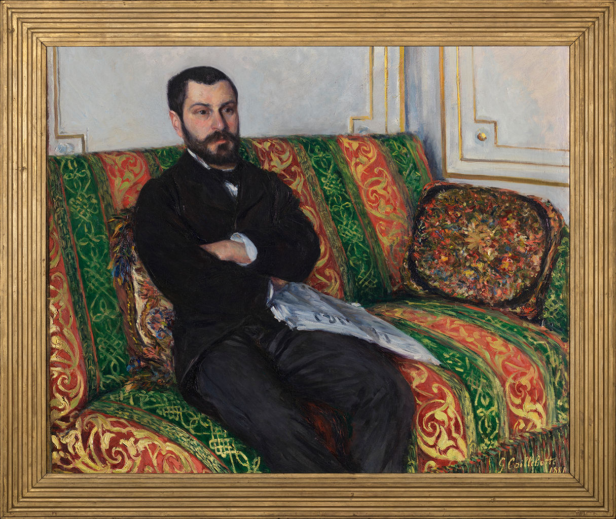 A painting depicting a man sitting on a vertically striped orange and green sofa with his arms crossed over his chest. The man wears a black coat and a black bowtie around his neck. A stack of papers lay on the side of his lap. The painting has a gold frame around it.