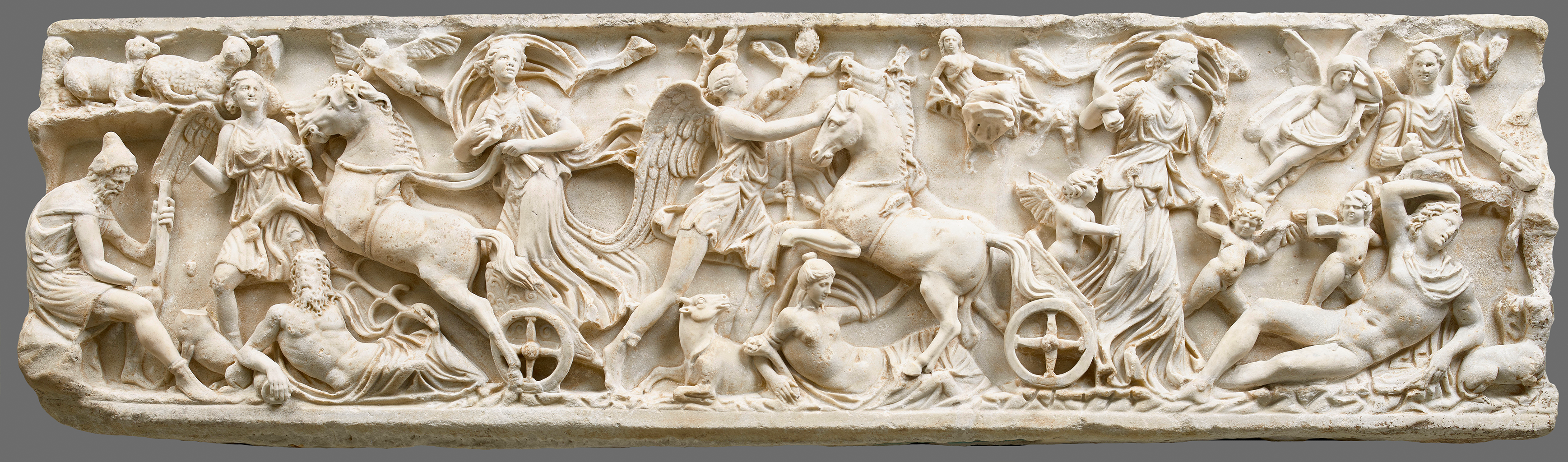 A marble sculpture depicting many mythological creatures and horses with chariots riding through the chaotic scene.