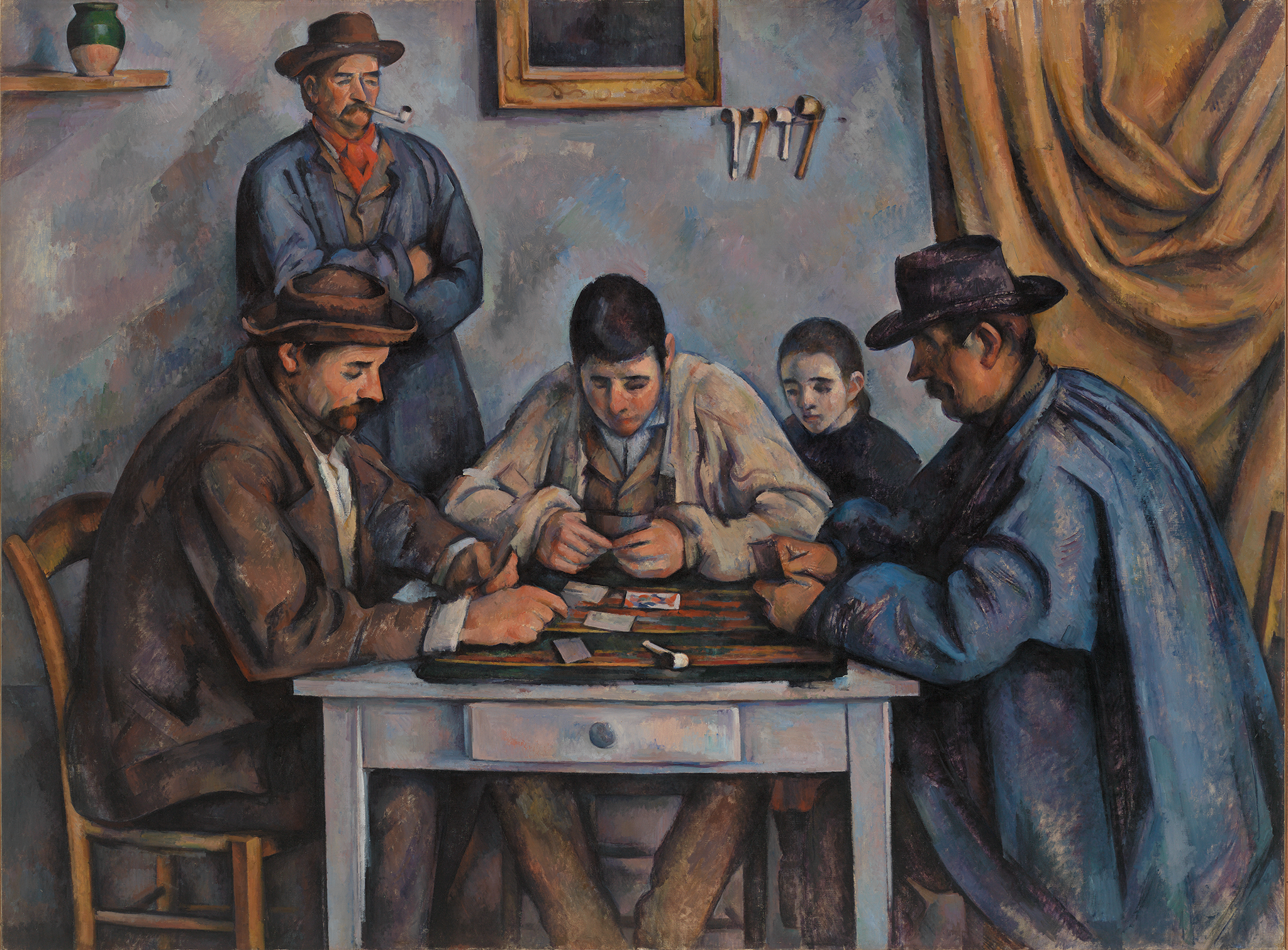 A painting depicting three men sitting down at a small white table playing a game of cards. The men wear brown, white, and blue coats along with brown and black brimmed hats. They focus on the cards in their hand and on the table. Behind the man in the middle seems to be a boy wearing a black clothing. In the background, there is a man against the light blue and green wall smoking a pipe. To his right is the bottom of a framed painting, a stand holding four other pipes, and a large golden cloth hanging.