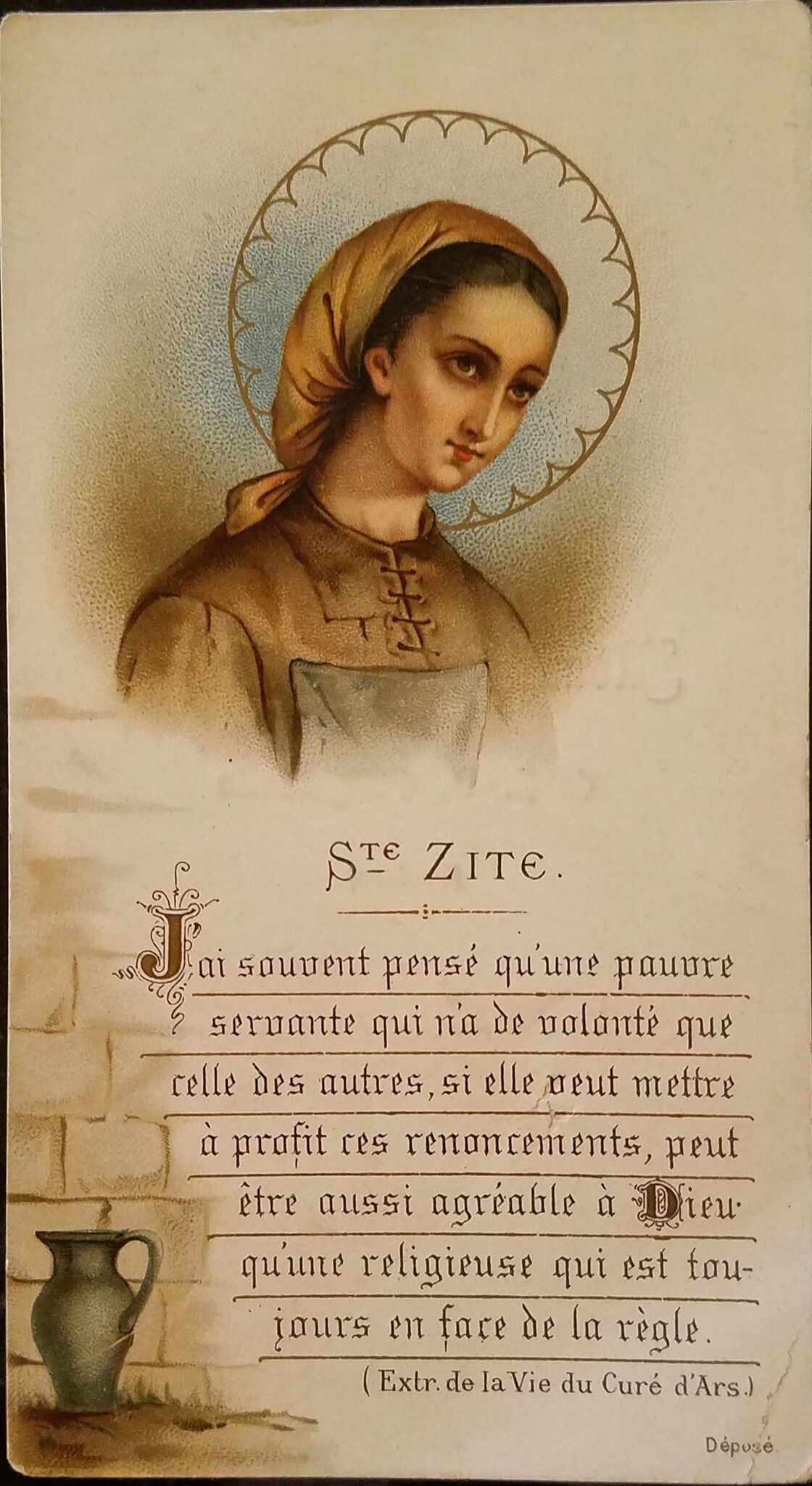 A card depicting an image of a woman. She has brown hair and a cloth head covering. She also wears a brown shirt with laces on the front.